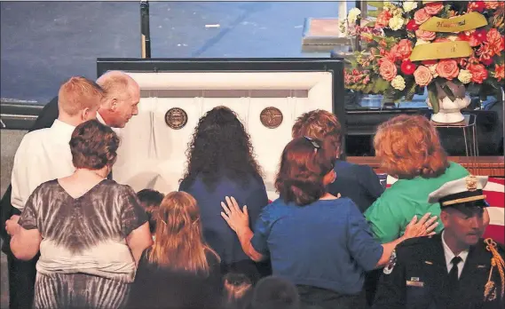  ?? [JOSHUA A. BICKEL/DISPATCH PHOTOS] ?? DiSario’s family gathers at his coffin before his funeral at Church of the Nazarene in Grove City, Ohio.