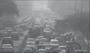  ?? MANISH SWARUP/AP and toxic smog in New Delhi, India ?? COMMUTERS DRIVE AMIDST MORNING HAZE Wednesday.