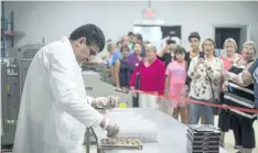  ?? DARREN CALABRESE/THE CANADIAN PRESS ?? Syrian chocolatie­r Assam Hadhad makes chocolate as members of the community tour Peace By Chocolate’s newly-opened factory in Antigonish, N.S.