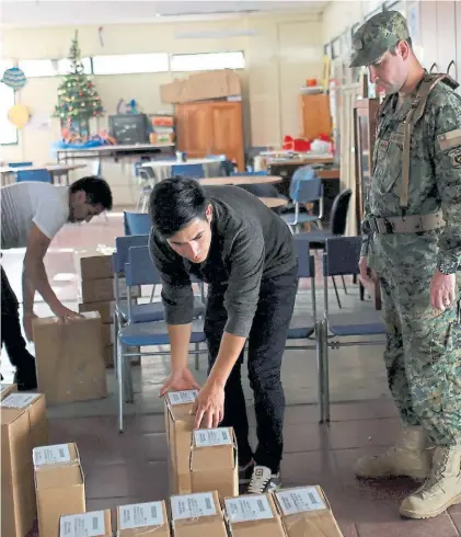  ?? AP ?? Alistamien­to. Los equipos electorale­s preparan boletas y urnas para la elección crucial de este domingo.