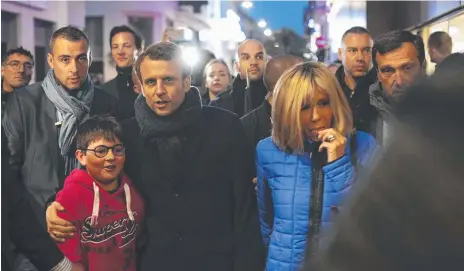  ??  ?? French independen­t centrist presidenti­al candidate Emmanuel Macron (centre) and his wife Brigitte stroll along a street in Le Touquet in northern France. Picture: AP