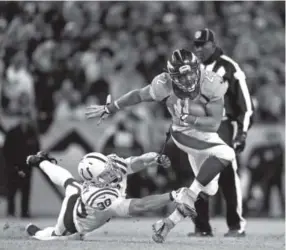  ??  ?? Broncos running back C.J. Anderson gains a first down against the efforts of the Indianapol­is Colts’ LaRon Landry in a playoff game. AAron Ontiveroz, The Denver Post