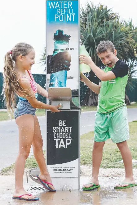  ?? Picture: GLENN HAMPSON ?? Kayla and Ryan Prigg from Upper Coomera try soaking each other at the refill station at Burleigh.