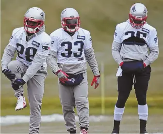  ?? StaFF PHOtO by JOHN WILcOX ?? WAITING GAME: Mike Gillislee (right) gets ready for practice yesterday at Gillette Stadium alongside fellow Patriots running backs James White (28) and Dion Lewis.