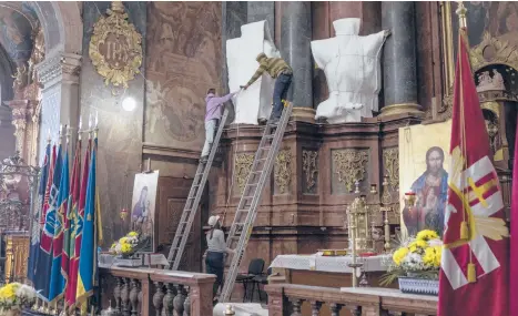  ?? DAN KITWOOD/GETTY ?? Statues are wrapped Saturday at the Saints Peter and Paul Garrison Church in Lviv, Ukraine.