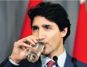  ?? KIRSTY WIGGLESWOR­TH / THE ASSOCIATED PRESS ?? Prime Minister Justin Trudeau takes a drink — no straw, of course — during a press conference at the High Commission of Canada in London on Thursday.