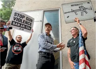  ?? AP ?? National Rifle Associatio­n member and Donald Trump supporter Jim Whelan, centre, argues with protesters outside the NRA’s annual convention in Dallas.