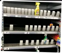  ??  ?? Empty shelves: Few cleaning products left at one Asda, inset, while a woman stocks up on kitchen roll and toilet paper, above