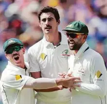  ?? AP ?? Teammates David Warner (left) and Nathan Lyon (right) congratula­te Australia’s Mitchell Starc after scalping the wicket of South Africa’s Dean Elgar in Adelaide.