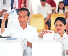  ?? — Reuters photo ?? Widodo and first lady Iriana cast their ballots during elections in Jakarta, Indonesia.