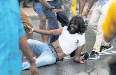  ?? REUTERS ?? A ruling party supporter tugs at the shirt of an anti-government demonstrat­or during a clash between the two groups in Colombo yesterday.