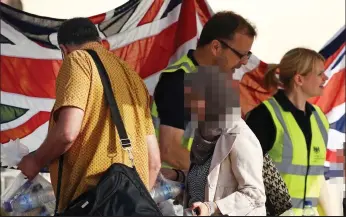  ??  ?? Relief: Evacuees collect bottles of water and food from British officials