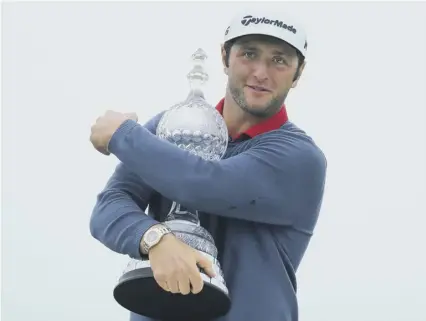  ??  ?? 2 Jon Rahm hugs the Dubai Duty Free Irish Open after his six-shot success at Portstewar­t, where he was cleared of any wrongdoing after incorrectl­y replacing his ball on the sixth green