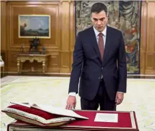  ?? — AFP ?? Formal affair: Sanchez taking the oath of office during his swearing-in at the Zarzuela Palace near Madrid.