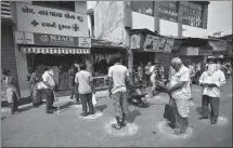  ?? AMIT DAVE / REUTERS ?? People stand in circles drawn with chalk to maintain social distancing while buying medicine on Wednesday during a 21-day nationwide lockdown in Ahmedabad, India.