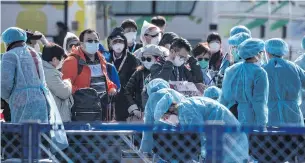  ??  ?? KEEP THEM APART: Workers in protective clothes check passengers disembarki­ng from the ‘Diamond Princess’ cruise ship on Friday as they head to quarantine due to fears of Covid-19.