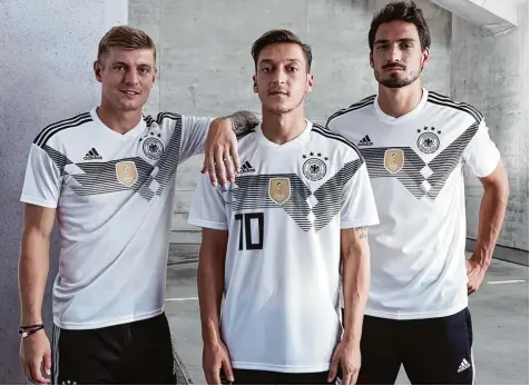  ?? Foto: dpa ?? Fototermin im Tiefgarage­n Ambiente: Die Nationalsp­ieler (von links) Toni Kroos, Mesut Özil und Mats Hummels präsentier­en das neue Trikot der deutschen Mannschaft für das WM Turnier 2018 in Russland. FUSSBALL GOLF