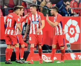  ?? — AFP ?? Atletico Madrid’s Antoine Griezmann (second from left) celebrates after scoring against Sevilla in their La Liga match in Sevilla on Sunday. Atletico won 5-2.