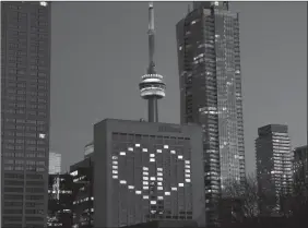  ?? The Canadian Press ?? Lights in rooms of the Hilton in Toronto are lit to honour frontline health workers on Sunday.