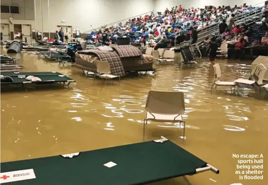  ??  ?? No escape: A sports hall being used as a shelter is flooded