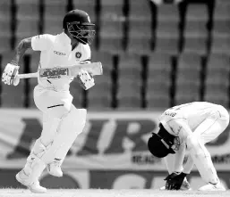  ?? AP ?? India’s captain Virat Kohli (left) scores runs against the Windies as wicketkeep­er Shai Hope hangs his head in frustratio­n during day three of the first Test match at the Sir Vivian Richards cricket ground in North Sound, Antigua and Barbuda, yesterday.