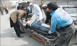  ?? RAHMAT GUL/AP ?? An injured man is carried into an ambulance after an attack Friday in the Afghan capital.