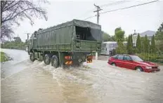  ?? AP ?? A New Zealand Army truck drives through a flooded street in ■ Christchur­ch, New Zealand, Saturday.A state of emergency was called by the Christchur­ch City Council on Saturday.