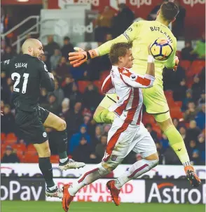  ??  ?? Manchester City’s midfielder David Silva (L) shoots past Stoke City’s goalkeeper Jack Butland to score his second goal during their English Premier League match at the Bet365 Stadium yesterday. –