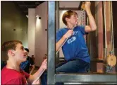  ??  ?? Kaid Goodwin helps Hunter Canard lift himself using pulleys at the Mid-America Science Museum. Some pulleys in the exhibit make it easier to lift yourself up, but others make it much harder.