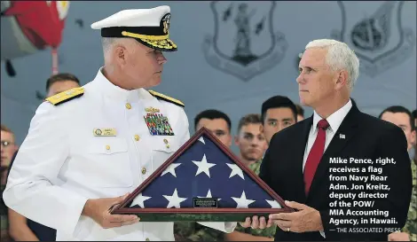  ?? — THE ASSOCIATED PRESS ?? Mike Pence, right, receives a flag from Navy Rear Adm. Jon Kreitz, deputy director of the POW/
MIA Accounting Agency, in Hawaii.
