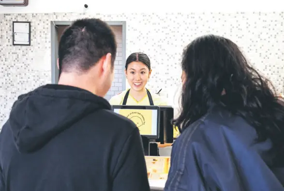  ?? — Amy Osborne for The Washington Post ?? Wang, 18, takes an order at work.