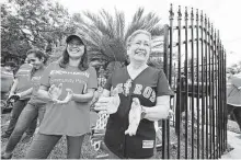  ?? Melissa Phillip / Staff photograph­er ?? Maria Garza, right, greets volunteers from ExxonMobil, who along with the nonprofit Rebuilding Together Houston made repairs at her 90-year-old Second Ward home Saturday.