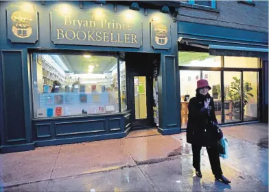  ?? BARRY GRAY THE HAMILTON SPECTATOR ?? Myrna Dolovich heads out into the rainy night with her last bag of books from the popular Westdale bookstore.