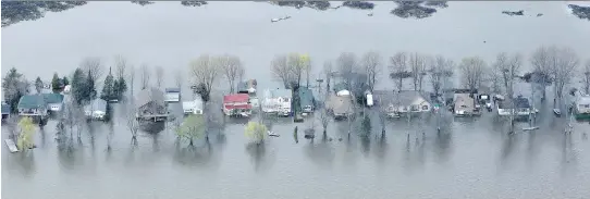  ?? JULIE OLIVER ?? A street of homes in a flooded area of Gatineau is practicall­y swallowed up as it is surrounded by the Ottawa River on all sides on May 8.