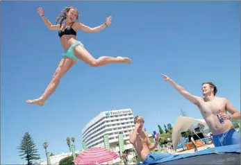  ?? PICTURE: EWALD STANDER ?? TAKE A LOAD OFF: Anya de Klerk jumps for joy as Plett Rage gets off to a sunny start. Cheering her on is Stefan Nieuwoudt, left, and Rohan de Klerk. The three were enjoying some fun in the sun on Plett’s Central Beach.