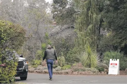  ?? JEFF CHIU/AP ?? A guard walks on a closed street near the family home of FTX founder Sam Bankman-Fried in Palo Alto, Calif., on Dec. 23.