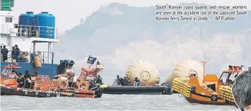  ??  ?? South Korean coast guards and rescue workers are seen at the accident site of the capsized South Korean ferry Sewol in Jindo. — AFP photo