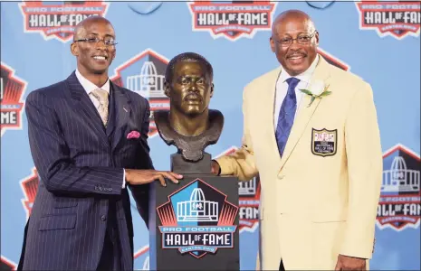  ?? Mark Duncan / Associated Press ?? Floyd Little, right, poses with his son Marc after enshrineme­nt in the Pro Football Hall of Fame in Canton, Ohio, in 2010.