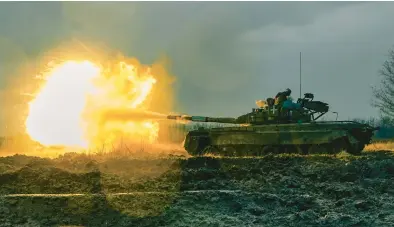  ?? LIBKOS 2022 ?? Soldiers in the Ukrainian army use a captured tank to fire toward a Russian position last fall in the Donetsk region of Ukraine.
