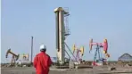  ?? — Reuters ?? A worker is seen near pumpjacks at a CNPC oil field in Bayingol, Xinjiang Region, China.