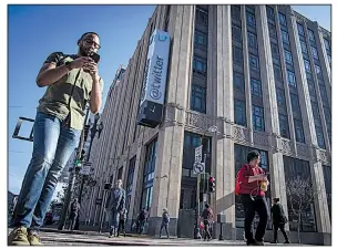  ??  ?? Pedestrian­s using Bloomberg News file photo their mobile phones walk past Twitter headquarte­rs in San Francisco.