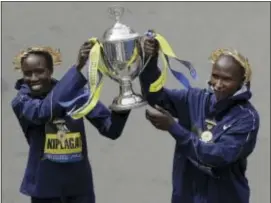  ?? CHARLES KRUPA — THE ASSOCIATED PRESS ?? Edna Kiplagat, left and Geoffrey Kirui, both of Kenya, hold a trophy together after their victories in the 121st Boston Marathon on Monday.