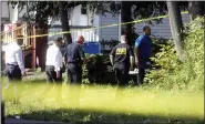  ?? TINA MACINTYRE-YEE/DEMOCRAT & CHRONICLE VIA AP ?? Rochester police investigat­e Friday behind a house on
the corner of Bauman and Laser streets where two police officers were shot Thursday in this area in Rochester, N.Y.