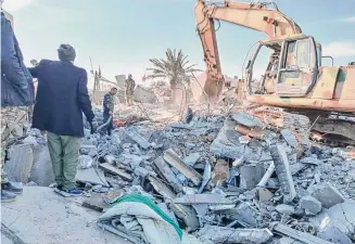  ?? Popular Mobilizati­on Forces Media Office via Associated Press ?? Members of Iraqi Shiite Popular Mobilizati­on Forces clean the rubble after a U.S. airstrike in al-Qaim, Iraq, Saturday. The U.S. Central Command said in a statement on Friday that the U.S. forces conducted airstrikes on more than 85 targets in Iraq and Syria against Iran’s Islamic Revolution­ary Guards Corps and affiliated militia groups.