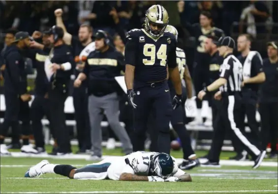  ?? BUTCH DILL — THE ASSOCIATED PRESS ?? Eagles wide receiver Alshon Jeffery (17) lies on the turf in front of Saints defensive end Cameron Jordan (94) after the Saints intercepte­d a pass in the final minutes of Sunday’s playoff game that went through Jeffery’s fingers. The Saints won, 20-14.