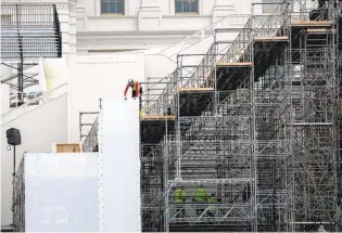  ?? JOHN MOORE GETTY IMAGES ?? Workers prepare a grandstand at the U.S. Capitol for the presidenti­al inaugurati­on on Jan. 20. The stands were partially damaged by a mob that stormed the Capitol on Wednesday.