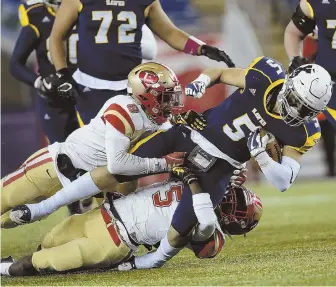  ?? STAFF FILE PHOTO BY NICOLAUS CZARNECKI ?? HIGH FIVES: Xaverian’s Mike Saliba tries to escape a tackle from Everett’s Mike Sainristil (5) and Robby Riobe during last year’s Division 1 Super Bowl. The teams meet again in tonight’s season opener in Westwood.