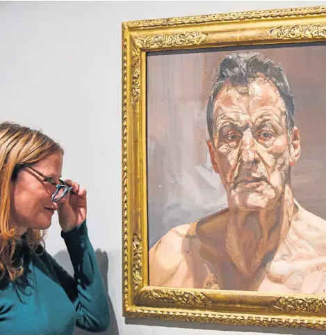 ?? Picture: Shuttersto­ck. ?? A staff member at the Royal Academy of Arts in London views Reflection (Self-Portrait), 1985 by Lucian Freud.