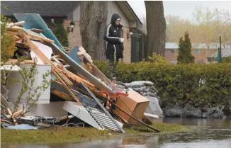  ?? ANNIK MH DE CARUFEL LE DEVOIR ?? Un résidant de L’Île-Bizard profitant d’un moment de répit avant de poursuivre le nettoyage de sa maison, en mai 2017