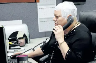  ?? CARRIE ANTLFINGER/AP PHOTO ?? Joyce Endresen wears an Optune therapy device for brain cancer, as she speaks on a phone at work in Aurora, Ill. She was diagnosed in December 2014 with Glioblasto­ma. She had two surgeries to remove the tumour as well as radiation and chemothera­py, but is now trying the new therapy that requires her to wear the electrodes on her head as much as possible. They create low intensity electric fields that disrupt cell reproducti­on, which makes the cells die.